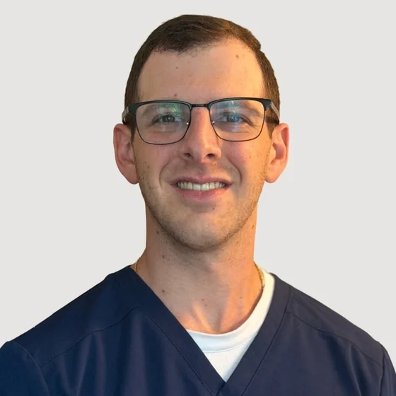 Dr. Zack Steinmetz of Athens Dental Associates, in navy scrubs.